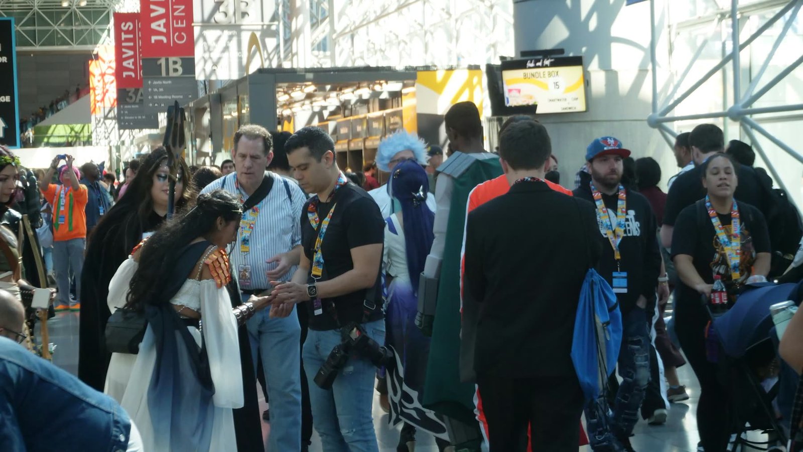 A crowded convention hall with attendees in costume
