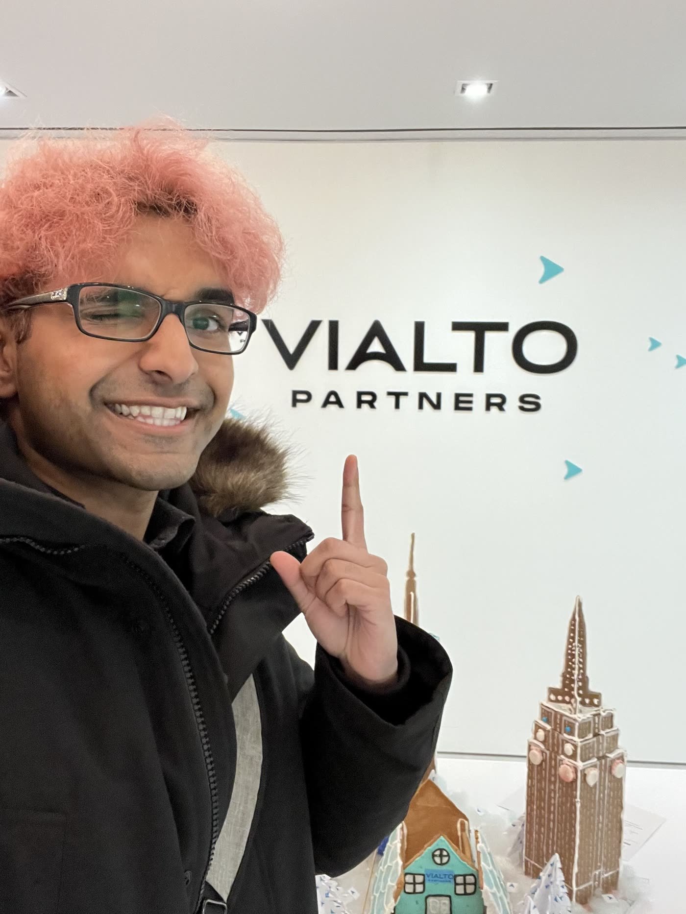 Nabeen pointing at the Vialto Partners sign in the Toronto office